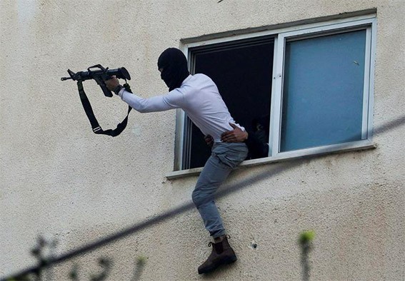 مقاتل فلسطيني يواجه الجيش الاسرائيلي